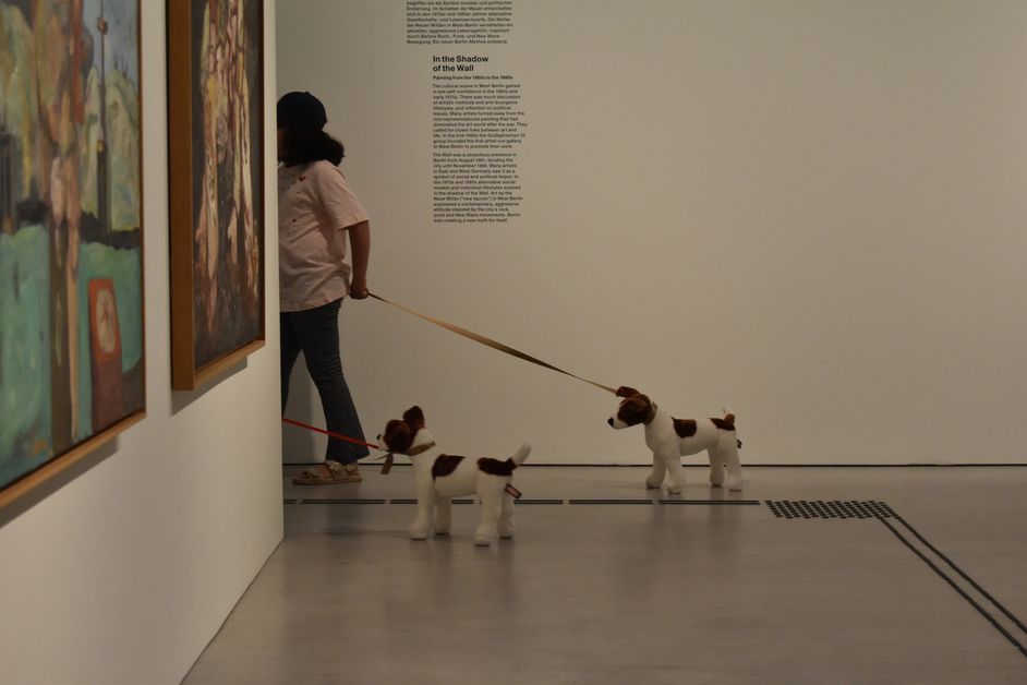Foto eines Kindes mit zwei Stoffhunden an der Leine in der Ausstellung