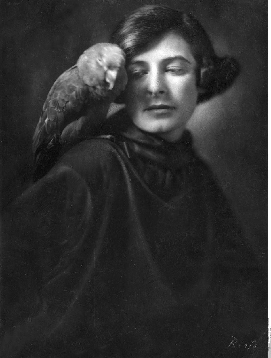 Black and white photo: Frieda. G. Riess, Self-portrait with parrot, 1922