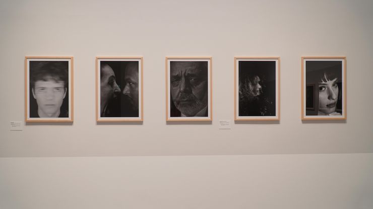 Foto: Fünf Foto-Porträts an einer Wand.