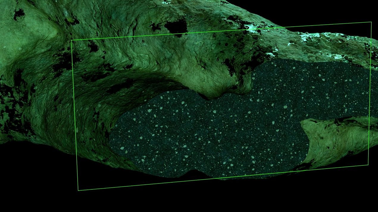 Rock surface in shades of green in which a rectangular area is highlighted with a translucent green frame. The highlighted area shows a dense structure with small, scattered dots that look like rock fragments or sediment particles.