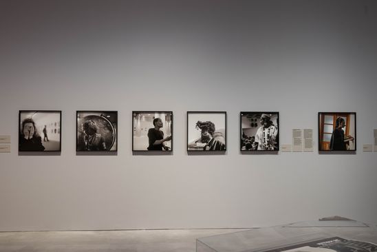 Ausstellungsansicht „Akinbode Akinbiyi“: Blick auf eine Portrait-Reihe, die aus quadratischen Schwarz-Weiß-Fotografien, die verschiedene Künstler*innen zeigen, besteht.