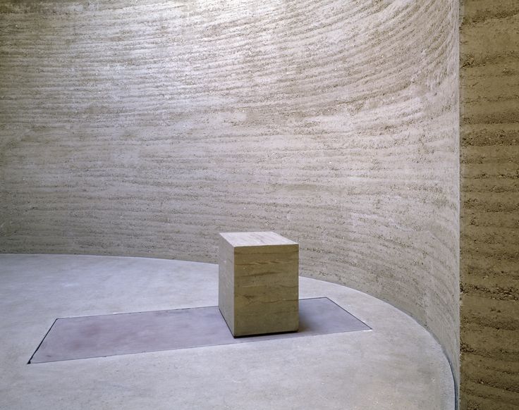 Martin Rauch, Lehmbau in der Kapelle der Versöhnung, 2000 Foto: Innenansicht eines runden, minimalistischen Innenraums aus Lehm mit einem kleinen Altar, der ebenfalls aus Lehm besteht.
