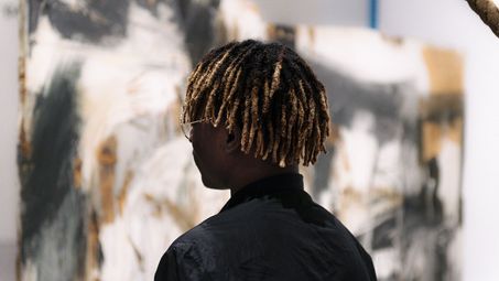 Photo: Visitor in front of a work of art, looking at the exhibit.