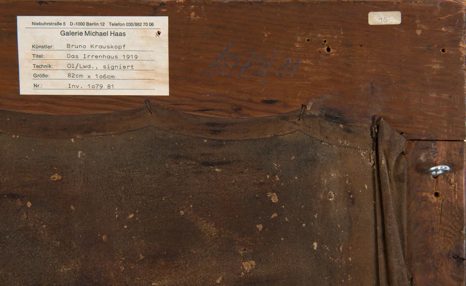 Rückseite eines Bilderrahmens, Detailansicht eines Aufklebers und einer handschriftlichen Notiz