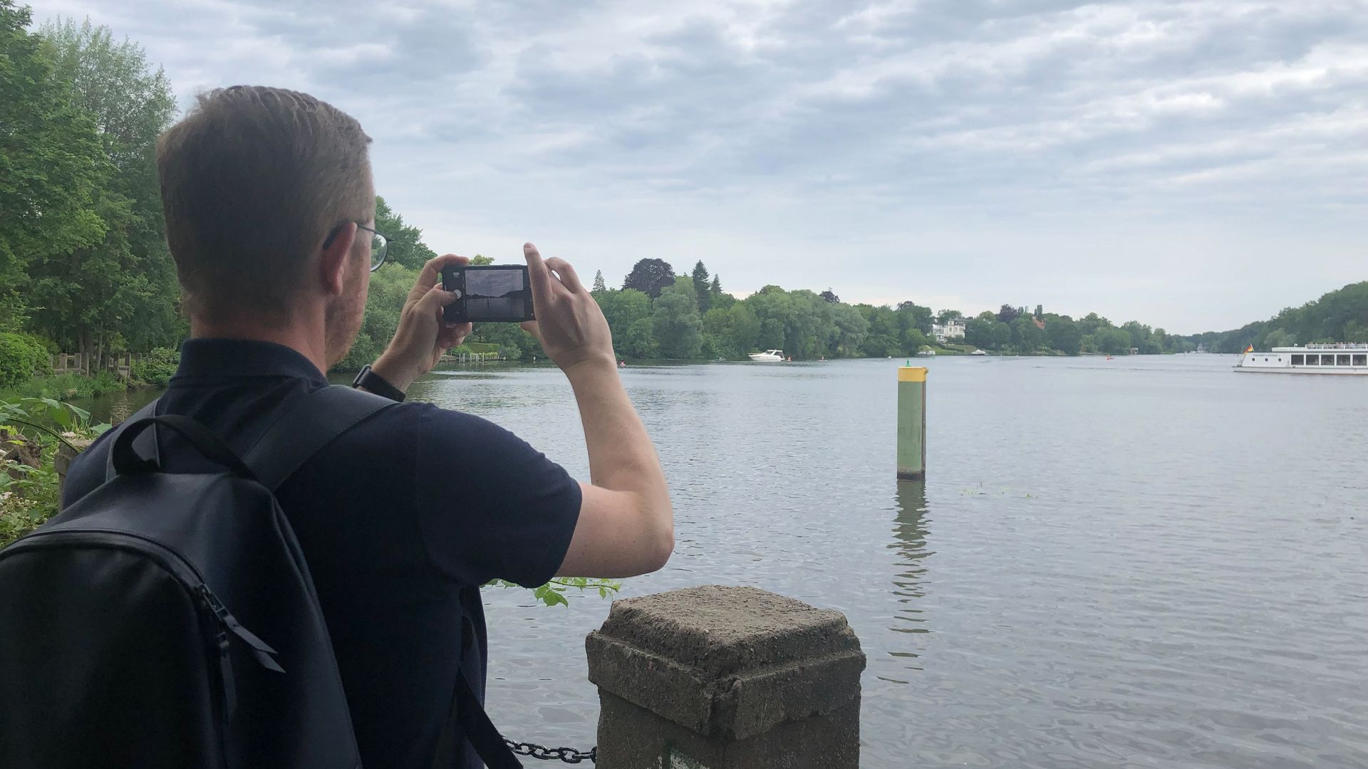 Foto: Person fotografiert eine Landschaft mit einem See.