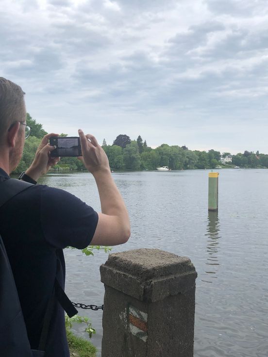 Foto: Person fotografiert eine Landschaft mit einem See.