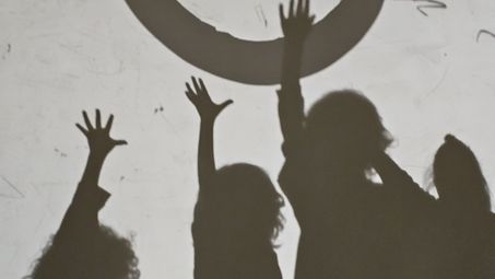 Schatten von Kindern, die in einen großen Ring greifen