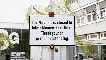 Cem A., "Thank you for your understanding", 2023 A sign in front of the Berlinische Galerie entrance reads “The Museum is closed to take a Moment to reflect. Thank you for your understanding.” In the background, the glass façade with the “BG Berlinische Galerie Museum für moderne Kunst” logo, green trees, and parts of the building are visible.