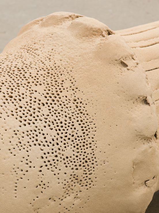 Foto: Close-Up einer auf dem Boden liegenden Skulptur aus Sand.