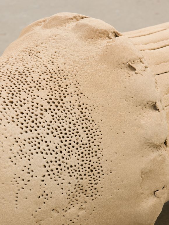 Foto: Close-Up einer auf dem Boden liegenden Skulptur aus Sand.