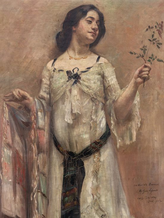 Painting of a woman in a white dress holding a small twig in her right hand. She has dark, tied-back hair, wears a delicate necklace, and gazes to the side with a slight smile. The dress is adorned with colorful fabric details and a dark belt. The background is rendered in warm, earthy tones.