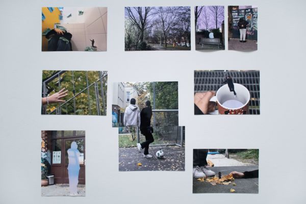 9 Fotos auf der Wand zeigen Ansichten aus dem Stadtraum der Kinder, in denen sie mit Größenverhältnissen spielen