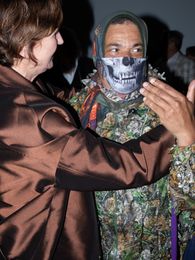 Foto: Marc Brandenburg in Tarn-Anzug, das Gesicht ist halb mit einer Art Tuch mit Skelett-Muster verdeckt.