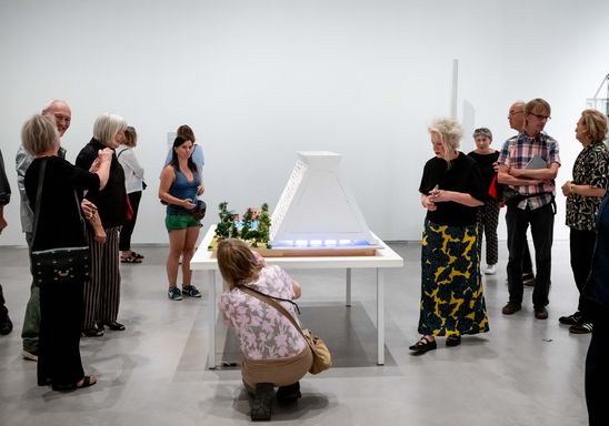 Foto: Eindrücke der Eröffnung, die entweder Menschen in den Ausstellungsräumen oder dem Außenraum der Berlinischen Galerie zeigen.
