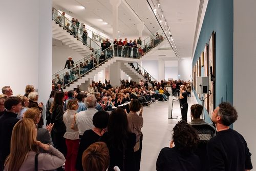 Foto: Eindrücke des Eröffnungsabends, die Menschen entweder bei den Eröffnungsreden in der Treppenhalle der Berlinischen Galerie oder in den Ausstellungsräumen zeigen.