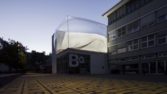 Außenansicht der Berlinischen Galerie bei Abenddämmerung mit einer Installation auf dem Dach