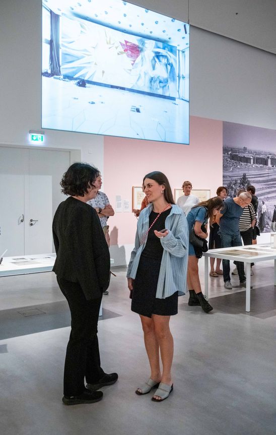 Foto: Eindrücke der Eröffnung, die entweder Menschen in den Ausstellungsräumen oder dem Außenraum der Berlinischen Galerie zeigen.
