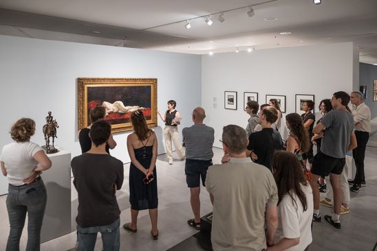 Foto: Eine große Gruppe Menschen steht als Teil einer Führung in einem Ausstellungsraum..