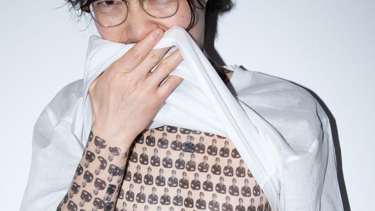 Foto: Mit Blitz aufgenommenes Foto von einer oberkörperfreien Person mit Klebetattoos von Marc Brandenburg auf dem ganzen Oberkörper.