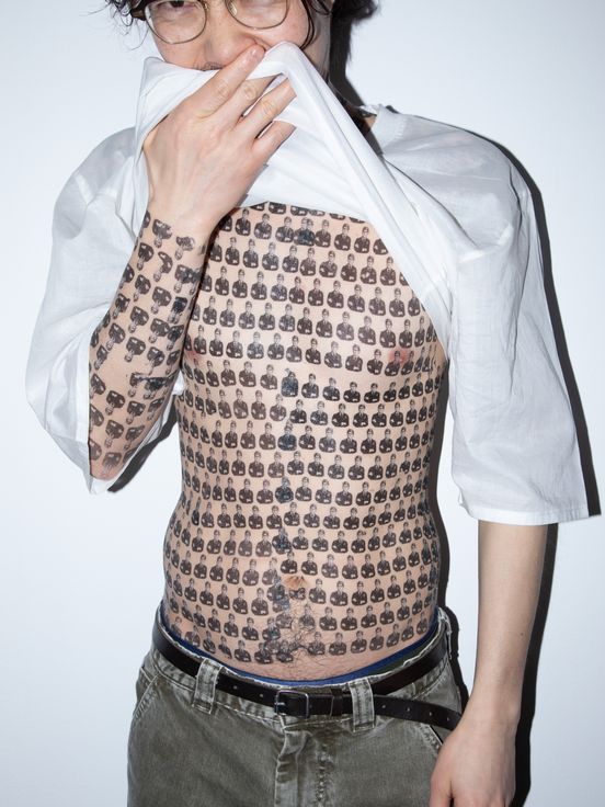 Foto: Mit Blitz aufgenommenes Foto von einer oberkörperfreien Person mit Klebetattoos von Marc Brandenburg auf dem ganzen Oberkörper.