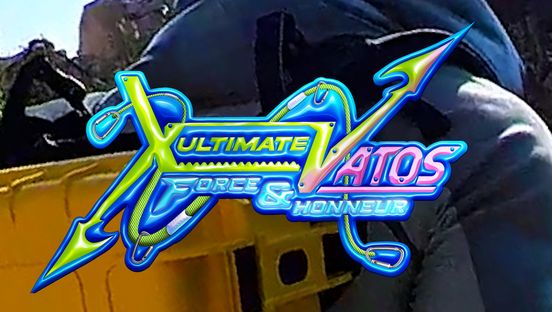 Film still: In a slightly blurred exterior shot, text appears in bright colours: ‘Ultimate Vatos – Force & Honneur’.