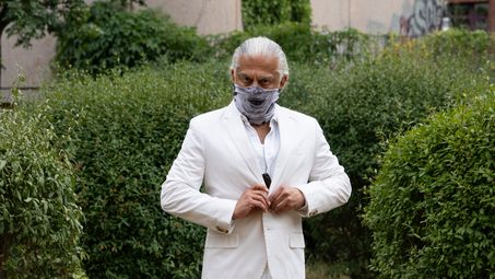 Foto: Eine Person posiert vor urbanem Hintergrund mit dem Loop-Schal, der wie eine Maske das halbe Gesicht verdeckt.