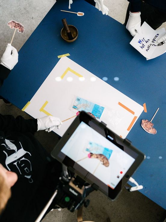 Photo: Children filming a picture on a table with a tablet.