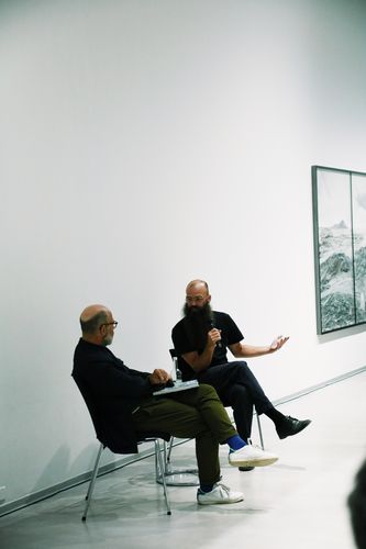 Impressionen Book Launch und Artist Talk mit Julius von Bismarck, Berlinische Galerie Zwei Personen sitzen auf Stühlen im Ausstellungsraum und unterhalten sich.
