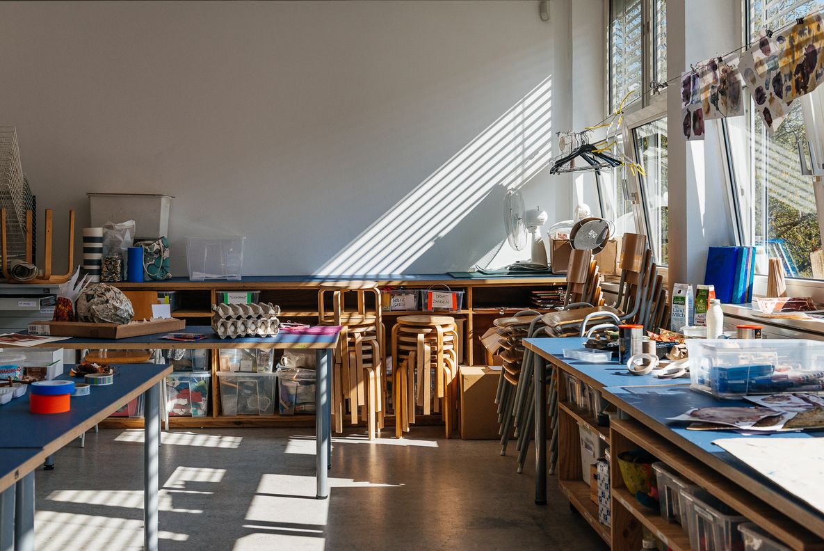 Foto: Ein Werkstattraum mit Arbeitstischen, Stühlen und Materialien.