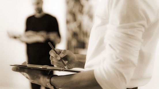 Photo: A person draws on a clipboard.