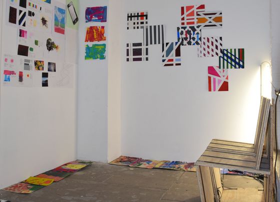 Foto: Viele bunte Bilder hängen an weißen Wänden.
