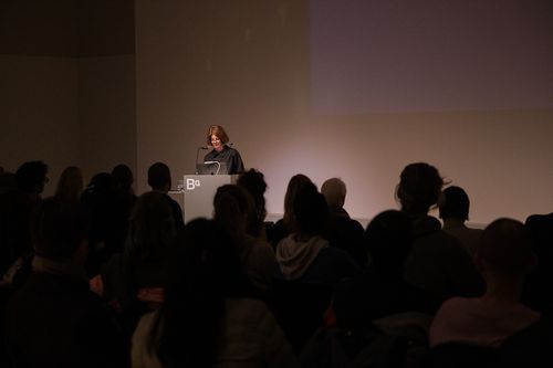 Photo: Anne Bitterwolf stands at a lectern in front of an audience.