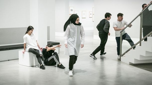 Foto: Jugendliche performen im Sitzen oder Laufen im Ausstellungsraum.