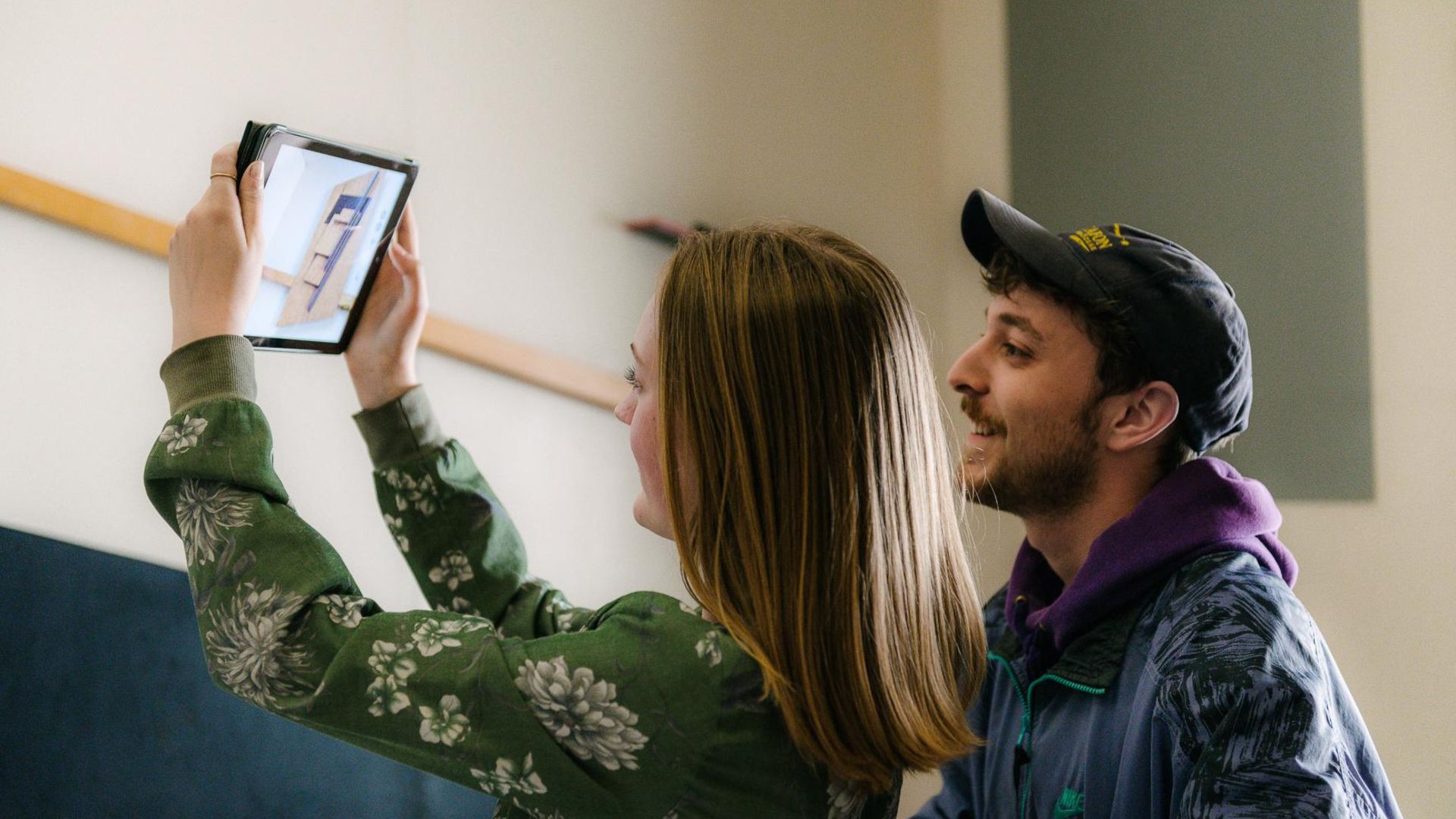 Foto: Zwei junge Besucher:innen halten ein Tablet. Es zeigt die Aufnahme eines Fotos von einem Kunstwerk.