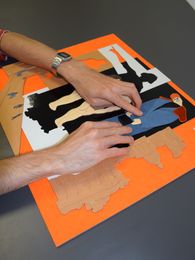 Foto: Zwei Hände betasten ein Tastmodell mit unterschiedlichen Materielien.