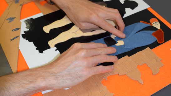 Foto: Zwei Hände betasten ein Tastmodell mit unterschiedlichen Materielien.