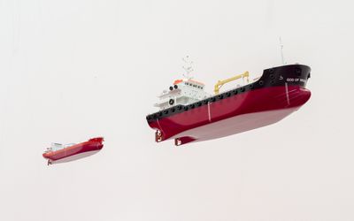 Blick von unten auf zwei von der Decke hängende Öltanker-Miniaturen.