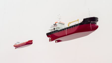 Blick von unten auf zwei von der Decke hängende Öltanker-Miniaturen.