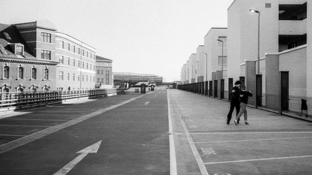 Schwarz-Weiß Fotografie: Verlassene Straßenflucht mit zwei Menschen.