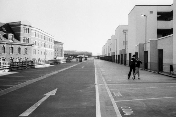 Schwarz-Weiß Fotografie: Verlassene Straßenflucht mit zwei Menschen.