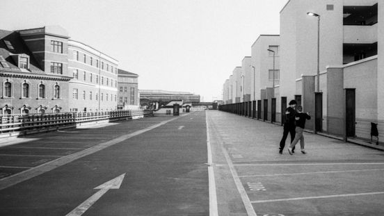 Schwarz-Weiß Fotografie: Verlassene Straßenflucht mit zwei Menschen.