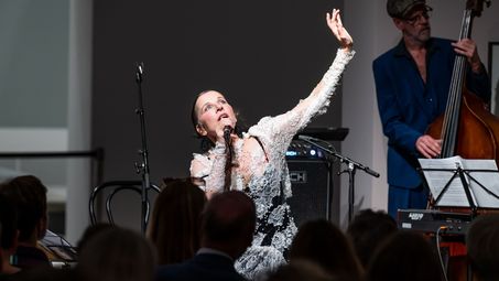 Foto: Meret Becker mit gestikulierendem Arm während sie singt.
