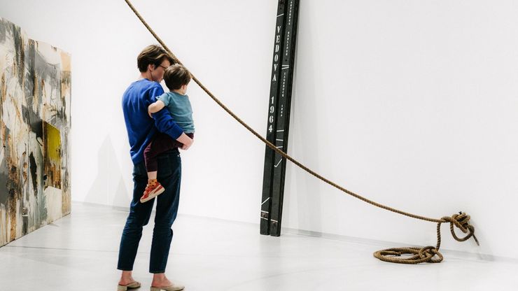 Photo: Woman and child on her arm looking at room installation.