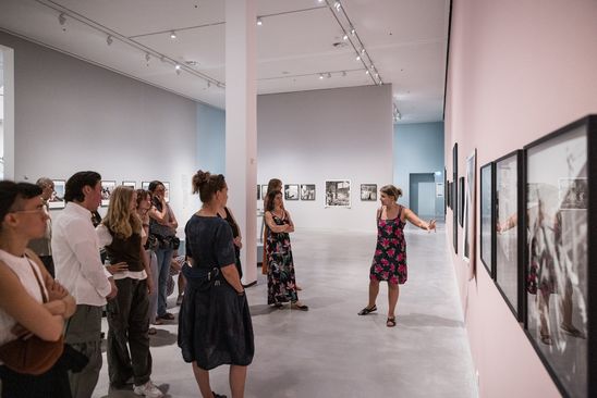 Foto: Eine große Gruppe Menschen steht als Teil einer Führung in einem Ausstellungsraum..