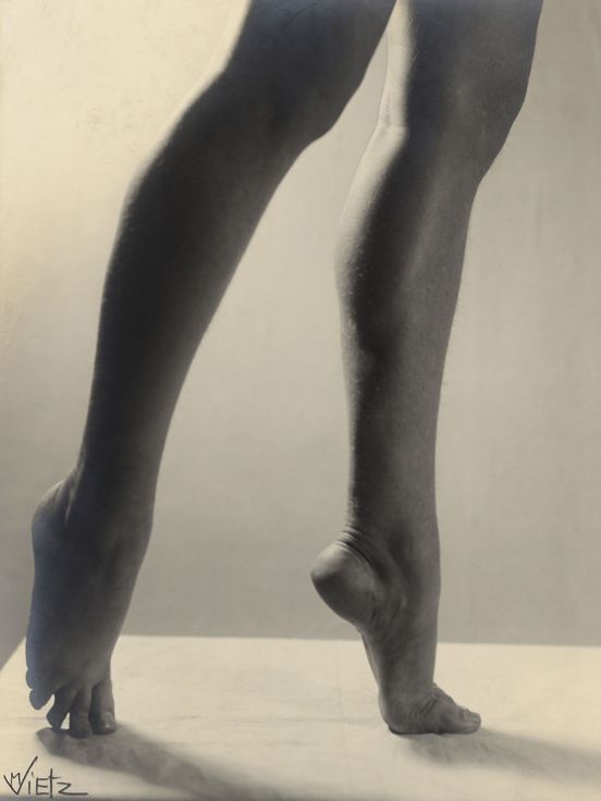 Sepia photograph: The photograph shows the legs of a person standing on tiptoe.