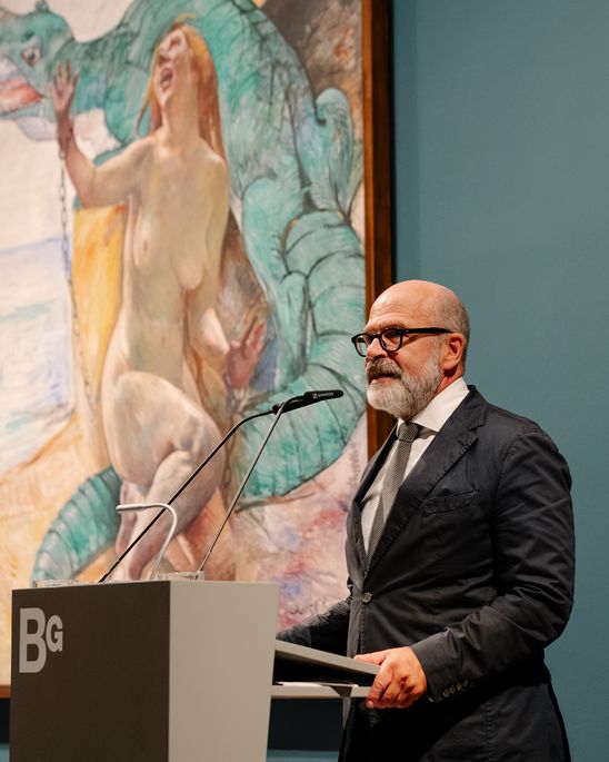 Photo: Thomas Köhler at the lectern in front of a large framed painting by Lovis Corinth.