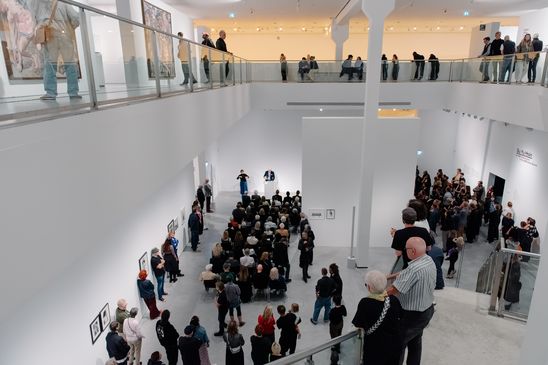 Foto: Eindrücke des Eröffnungsabends, die Menschen entweder bei der Verleihung in der Treppenhalle der Berlinischen Galerie oder zwischen Jeewi Lees Installation im Ausstellungsraum zeigen.
