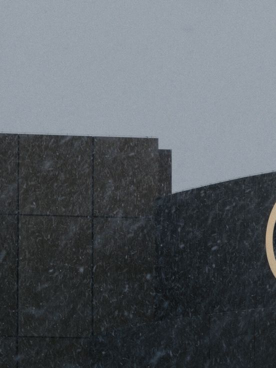 Film still: The still shows a close-up of the front of the Olympia shopping centre in Munich and part of the lettering on the building’s façade in gold letters.