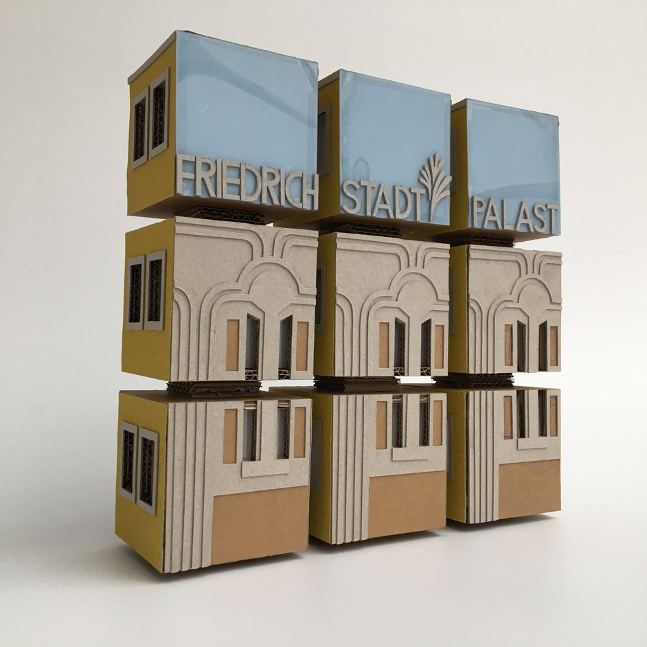 Berlin-Museum_Barrierefreiheit_Tastmodell_TU-Berlin_Entwurf-Friedrichstadt-Palast Tastobjekt aus 9 Papp-Würfeln, die einen Quader bilden. Die Fassade eines Hauses und die Worte "Friedrichstadt-Palast" sind taktil hervorgehoben.