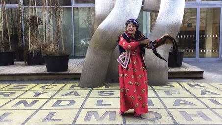 Tanzende Frau in traditionellem Kleid vor der Berlinischen Galerie
